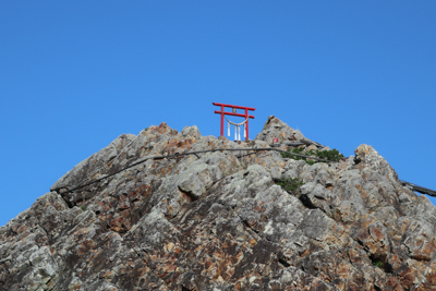 夫婦石の上に鳥居が立っている。...